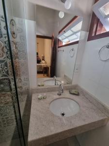 チラデンテスにあるPouso dos Arcanjosの洗面台と鏡のあるバスルーム +80枚の写真