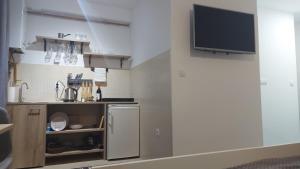 a small kitchen with a tv on a wall at River stay in Sremska Mitrovica +5 photos