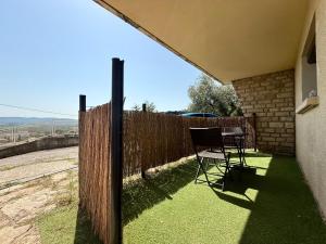 a chair sitting on a lawn next to a fence at Studio cosy tout équipé in Laudun
