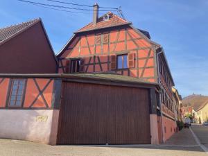 een groot oranje gebouw met een garage bij Eulia, A l'Orée des Vignes in Orschwiller