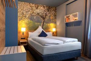 a bedroom with a bed with a painting on the wall at Boutique Hotel Zum grünen Baum in Alzenau in Unterfranken