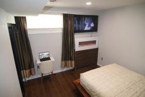 a bedroom with a bed and a tv on the wall at beautiful private house in Edmonton