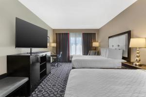 a hotel room with two beds and a flat screen tv at Best Western Plus Laredo Inn & Suites in Laredo