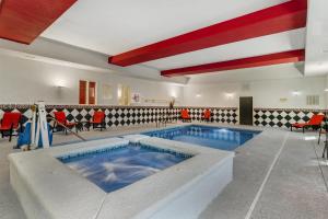 a large swimming pool in a room with red chairs at Best Western Plus Laredo Inn & Suites in Laredo