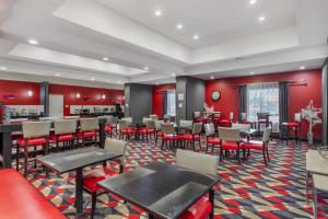 a restaurant with red walls and tables and chairs at Best Western Plus Laredo Inn & Suites in Laredo