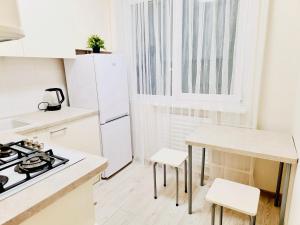 a kitchen with white appliances and a table and chairs at M&M Apartment V SELF CHECK-IN in Panevėžys