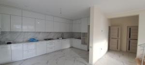 - une cuisine blanche avec des placards blancs et du carrelage blanc dans l'établissement Будинок для відпочинку, à Borysxaw