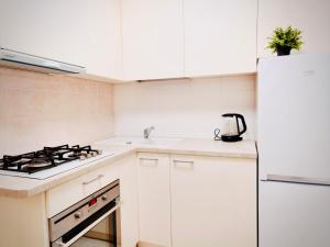 a white kitchen with a stove and a refrigerator at M&M Apartment V SELF CHECK-IN in Panevėžys