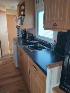 スケッグネスにあるE12 jeans caravan The Chaseのキッチン(黒いカウンタートップ、シンク付)