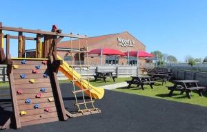 a playground with a slide and tables and a building at The Chase Caravan Park ref E in Skegness