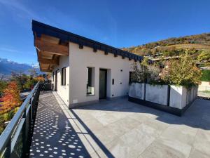 Ein weißes Haus mit Balkon und Bergen im Hintergrund in der Unterkunft La Dimora del Monte Bianco in Aosta