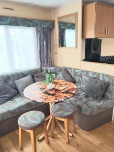 a living room with a table and a couch at The Chase Caravan Park ref E in Skegness