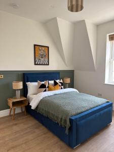 レイバーンにあるElegant 2 bed Penthouse in Leyburnのベッドルーム(ブルーベッド1台、枕付)