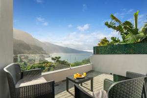einen Balkon mit Stühlen, einem Tisch und Meerblick in der Unterkunft Atlantic View Studio in Ponta Delgada