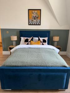 レイバーンにあるElegant 2 bed Penthouse in Leyburnのベッドルーム(2つのランプ付)の青いベッド1台