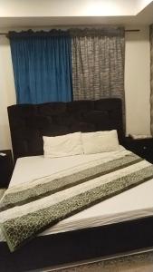 a bedroom with a large bed with a blue window at Afzal real estate builder's in Islamabad
