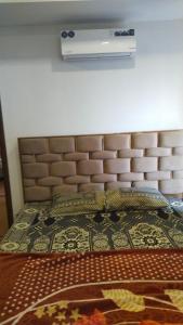 a bedroom with a bed with a large headboard at Afzal real estate builder's in Islamabad