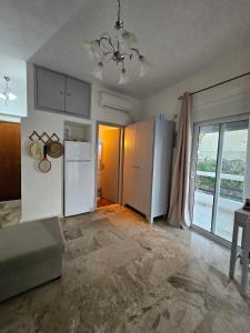 a kitchen with a white refrigerator and a window at Aghia Marina, Aegina Studio in Aegina Town