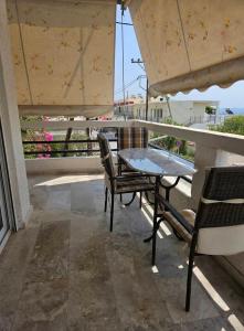 a table and chairs on a balcony with an umbrella at Aghia Marina, Aegina Studio in Aegina Town