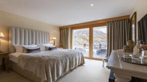 a bedroom with a large bed and a large window at Entrebin PremiumChalet AO in Aosta