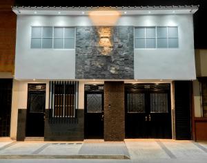 a building with black doors and a stone wall at ELEGANTE, CÓMODO Y MODERNO APARTAMENTO - SUR DE CALI in Cali