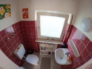 een badkamer met een wastafel en een toilet en een raam bij Moderne Zimmer in Steinhagen mit Balkon in Steinhagen