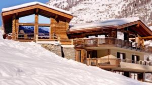 a log cabin in the snow with a pile of snow at Entrebin PremiumChalet AO in Aosta