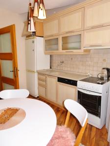 a kitchen with white appliances and a table and chairs at Chez Apartment in Prizren