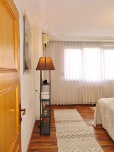 a bedroom with a bed and a lamp in a room at Chez Apartment in Prizren