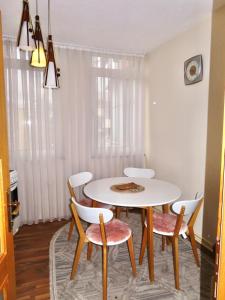 a dining room with a white table and chairs at Chez Apartment in Prizren +15 photos