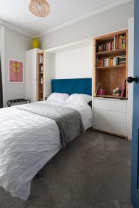 a bedroom with a large bed and a book shelf at Traditional apt close to city centre & Hampden in Glasgow +18 photos