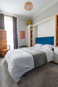 a bedroom with a large bed with a blue headboard at Traditional apt close to city centre & Hampden in Glasgow