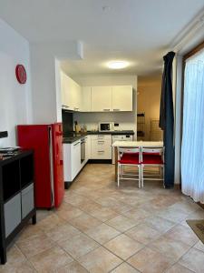 eine Küche mit einem roten Kühlschrank und einem Tisch in der Unterkunft Pragma Apartments - Appartamento La Torre in Predazzo