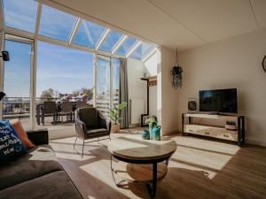a living room with a couch and a tv at Apartment in Waterpark in Uitgeest in Uitgeest