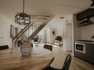a kitchen and dining room with a table and a staircase at Apartment in Waterpark in Uitgeest in Uitgeest