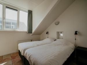 two beds in a room with two windows at Apartment in Waterpark in Uitgeest in Uitgeest