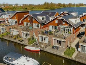 an aerial view of a house with a boat in the water at Apartment in Waterpark in Uitgeest in Uitgeest