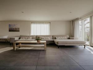 a living room with a couch and a table at Waterside Escape with Easy Access in Uitgeest