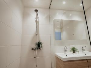 a white bathroom with a shower and a sink at Waterside Escape with Easy Access in Uitgeest +33 photos
