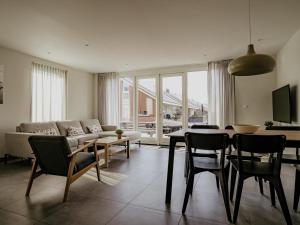 a living room with a table and a couch at Waterside Escape with Easy Access in Uitgeest