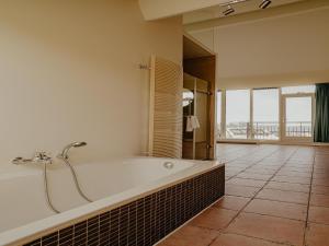 a large bathroom with a tub and a large window at Penthouse with Lake Views in Uitgeest +33 photos