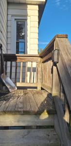 eine Holzbank auf der Veranda eines Hauses in der Unterkunft Century House on Quarter acre lot in Acton