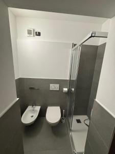 ein Badezimmer mit Dusche, Toilette und Waschbecken in der Unterkunft Pragma Apartments - Appartamento La Torre in Predazzo