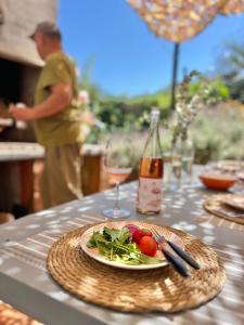 a table with a plate of food and a glass of wine at Viento Azul Guest House in Punta del Este