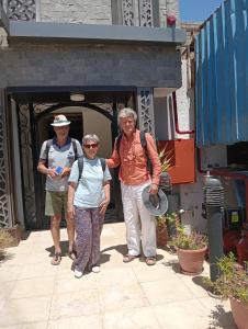 een groep van drie personen die voor een gebouw staan bij Summer Land Hotel in Abu Simbel