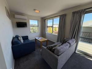 a living room with two couches and a table at Braeview Cottage in Lake Tekapo