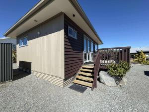 a small house with a staircase next to it at Braeview Cottage in Lake Tekapo