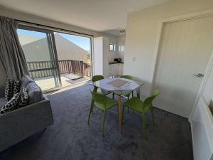 a room with a table and chairs and a balcony at Braeview Cottage in Lake Tekapo