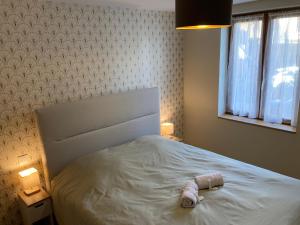 een slaapkamer met een wit bed met een fles erop bij Eulia, A l'Orée des Vignes in Orschwiller