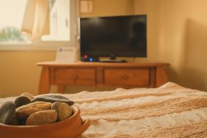 a bowl of rocks sitting on a bed with a television at Hotel Aparts Cabañas Tierra de Glaciares in El Calafate